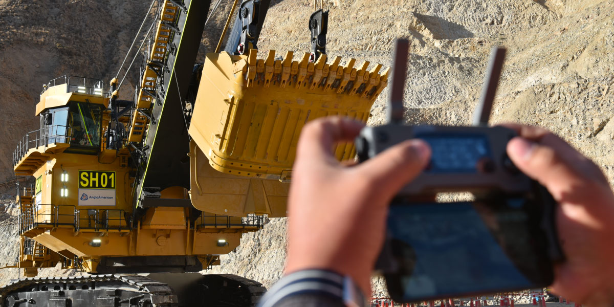 A person operating a heavy truck with remote